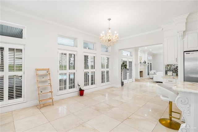 living room featuring a chandelier, light tile patterned floors, decorative columns, and ornamental molding