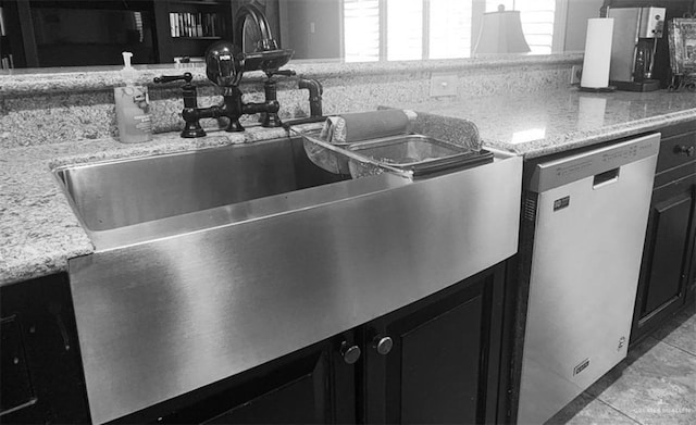 details featuring dishwasher, sink, and light stone countertops