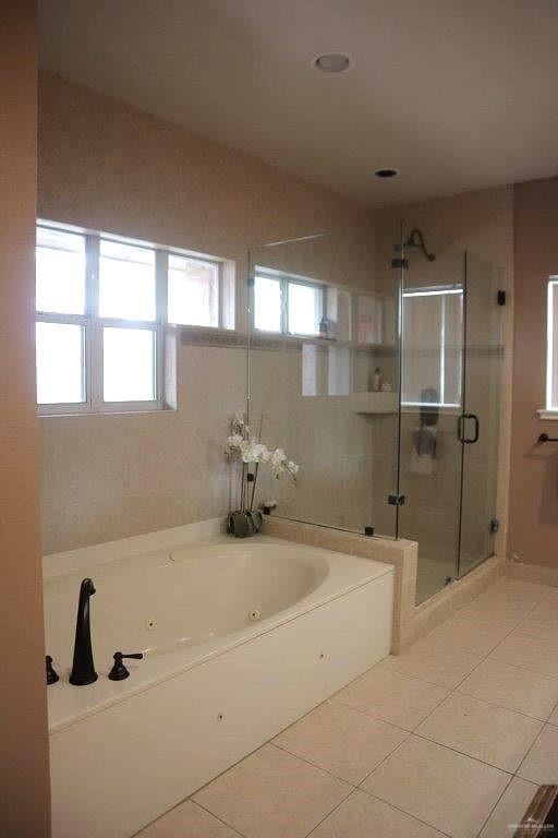 bathroom featuring tile patterned flooring and shower with separate bathtub