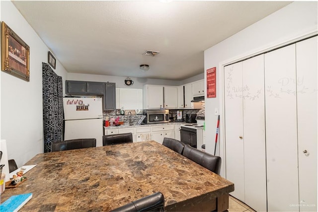 905 N 6th Ave, Edinburg, TX 78541 - kitchen with white appliances, under cabinet range hood, a breakfast bar area, and a sink