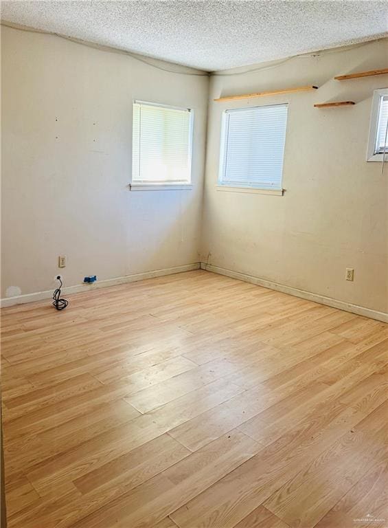 empty room featuring light hardwood / wood-style flooring and a textured ceiling