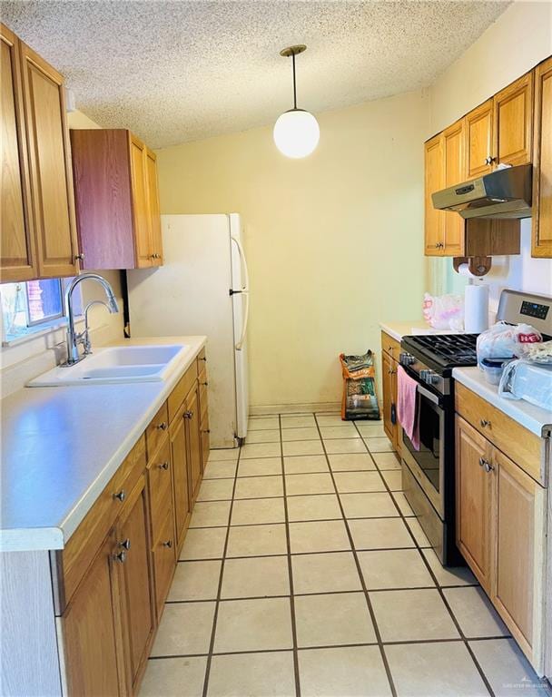 kitchen with sink, hanging light fixtures, a textured ceiling, light tile patterned flooring, and stainless steel range with gas stovetop