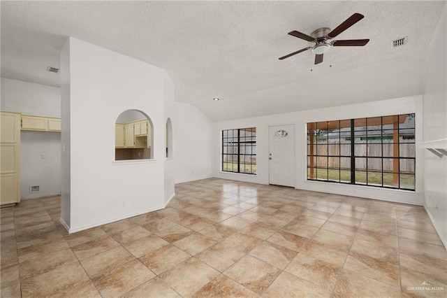 tiled empty room featuring vaulted ceiling, a textured ceiling, and ceiling fan