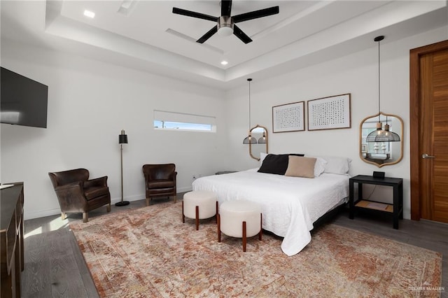 bedroom featuring a raised ceiling, ceiling fan, and hardwood / wood-style floors