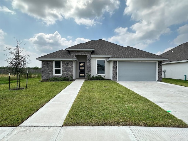 prairie-style house featuring a garage and a front yard