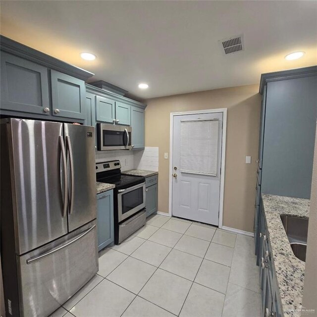 9218 N 29th Ln, Mcallen, TX 78504 - kitchen with light tile patterned floors, light stone counters, stainless steel appliances, and visible vents