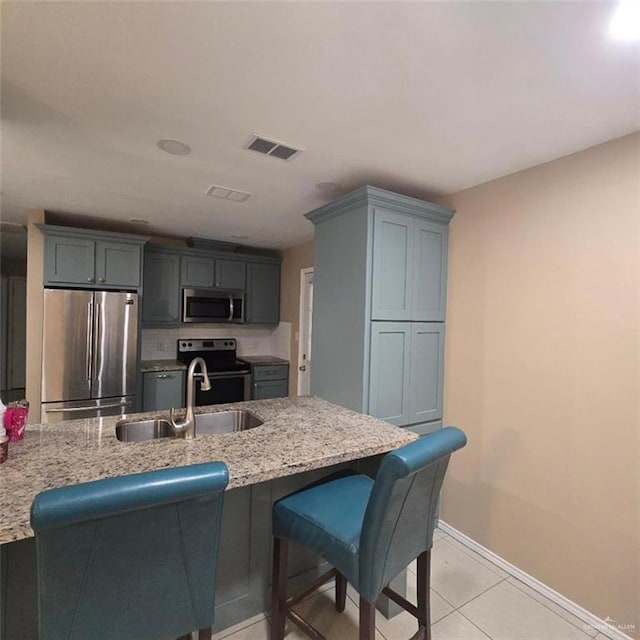 9218 N 29th Ln, Mcallen, TX 78504 - kitchen with a breakfast bar, a sink, stainless steel appliances, baseboards, and visible vents