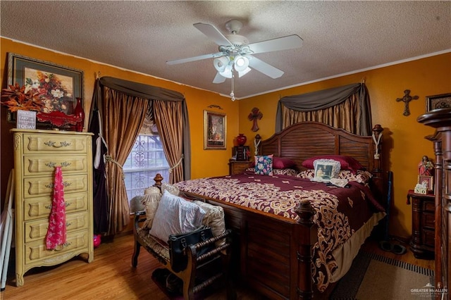 bedroom featuring ceiling fan, crown molding, wood-type flooring, and a textured ceiling