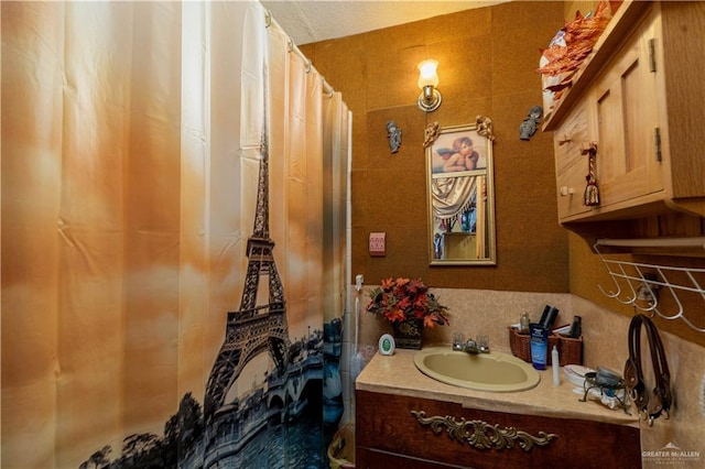 bathroom with a shower with shower curtain, vanity, and backsplash