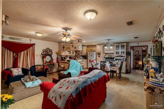 living room with crown molding, ceiling fan, and a textured ceiling