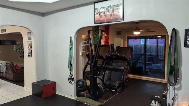 workout room featuring ceiling fan and tile patterned flooring