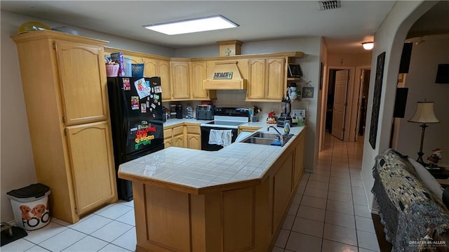 kitchen featuring light brown cabinets, sink, tile countertops, black appliances, and custom range hood