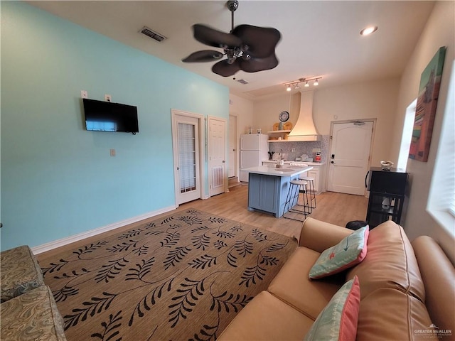 living room featuring light hardwood / wood-style flooring and ceiling fan