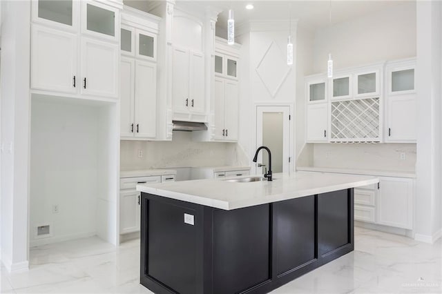 kitchen featuring white cabinetry, sink, and a center island with sink