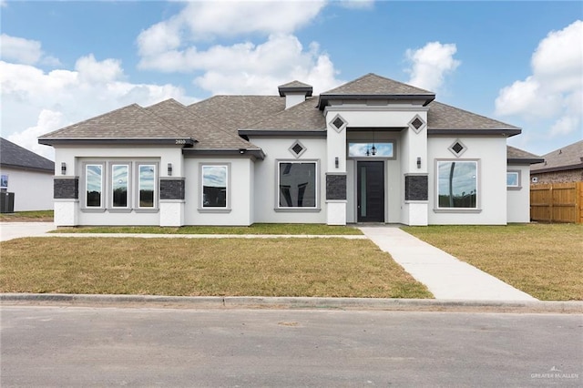 prairie-style home with a front yard and central air condition unit