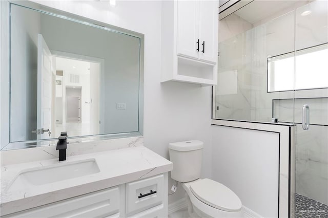 bathroom featuring vanity, a shower with door, and toilet