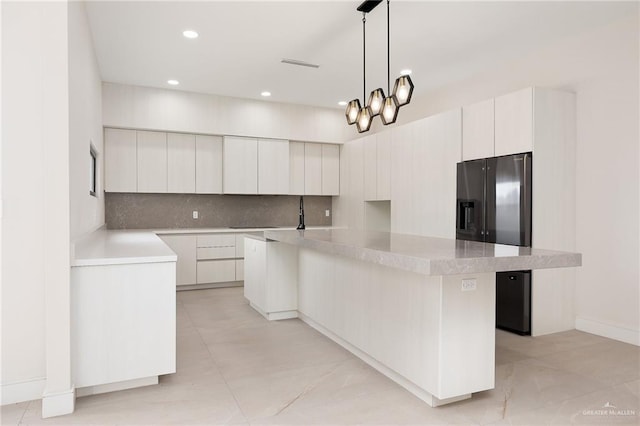 kitchen featuring white cabinets, decorative light fixtures, a kitchen island with sink, a chandelier, and black fridge with ice dispenser