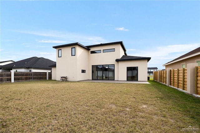 rear view of house with a lawn and a patio