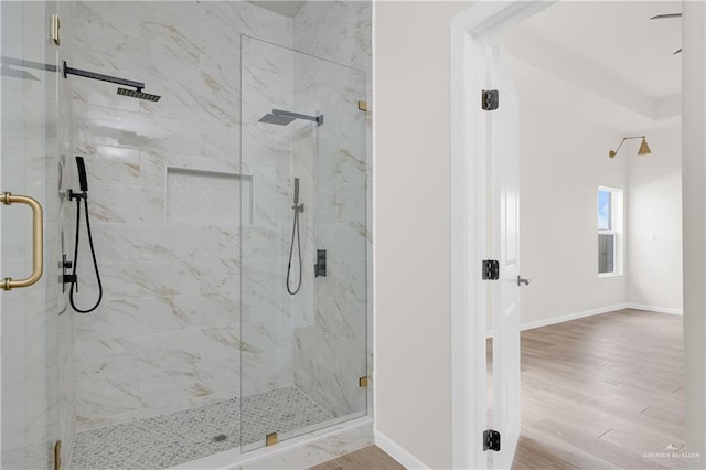 full bath with a shower stall, wood finished floors, and baseboards