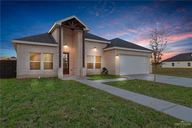 view of front of home with brick siding, a shingled roof, an attached garage, a front yard, and driveway