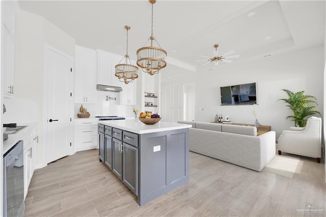 kitchen with white cabinetry, open floor plan, light countertops, a center island, and pendant lighting