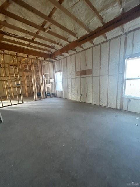 miscellaneous room featuring a garage and unfinished concrete flooring