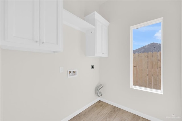 washroom with hookup for a washing machine, baseboards, light wood-type flooring, cabinet space, and electric dryer hookup