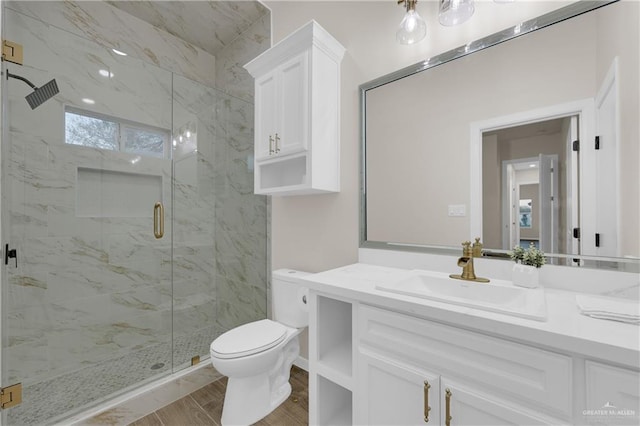 full bathroom with vanity, wood finished floors, a marble finish shower, and toilet