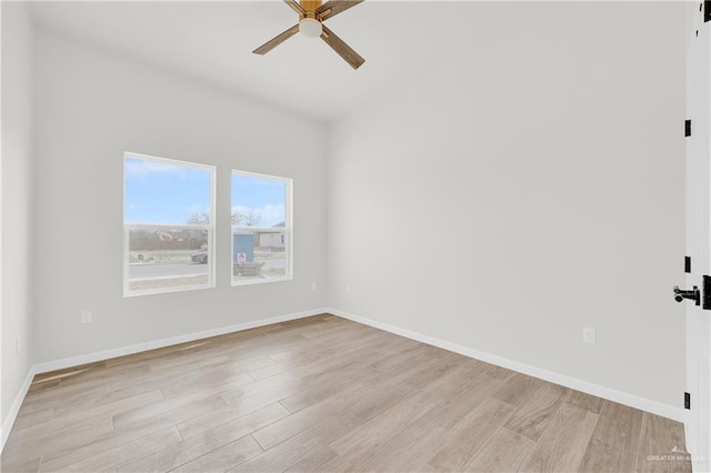 spare room with ceiling fan, baseboards, and light wood-style flooring