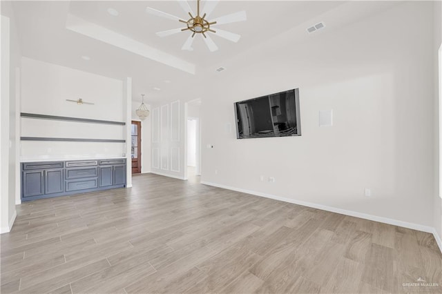 unfurnished living room with visible vents, light wood-style flooring, and baseboards