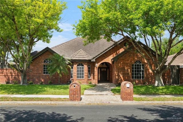 view of front of home with brick siding and a front yard