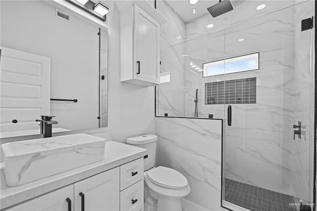 full bath featuring a marble finish shower, visible vents, toilet, vanity, and recessed lighting