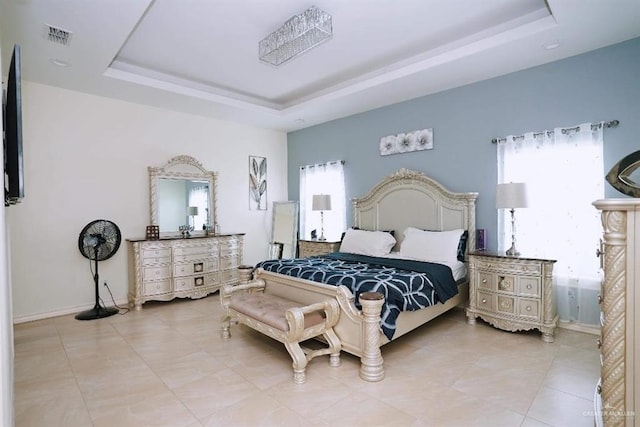 bedroom featuring a tray ceiling and multiple windows