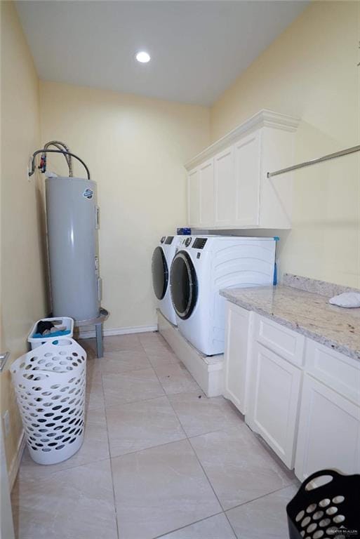 clothes washing area with cabinets, electric water heater, and separate washer and dryer