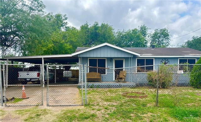 607 S Mile 1 Rd, Mission, TX 78572 - view of front of home with a gate, fence, board and batten siding, and an attached carport