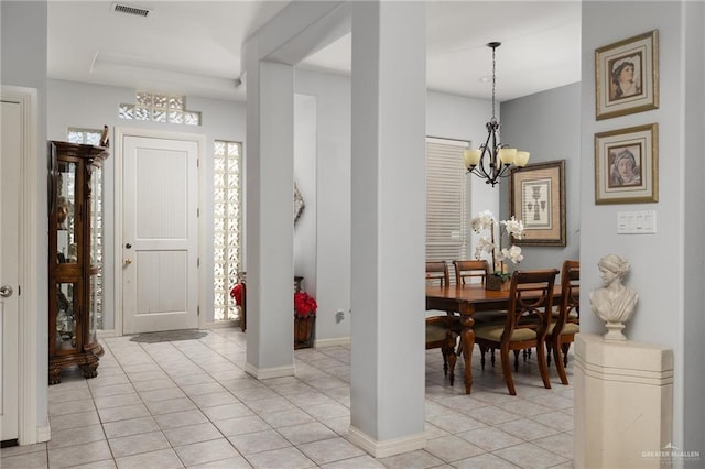 foyer featuring light tile patterned floors, visible vents, baseboards, and a chandelier