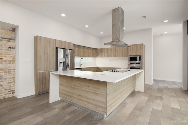 3804 S M St, Mcallen, TX 78503 - kitchen featuring modern cabinets, island exhaust hood, appliances with stainless steel finishes, light wood-style floors, and light countertops
