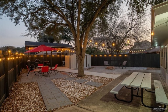 patio terrace at dusk with a shed and an outdoor fire pit