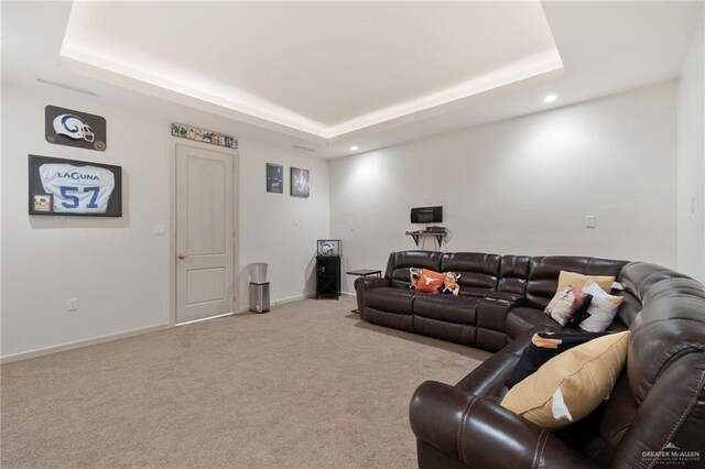 carpeted living area with recessed lighting, a raised ceiling, and baseboards