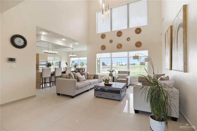 tiled living area with baseboards, a high ceiling, and an inviting chandelier