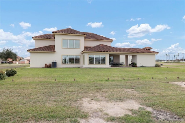 rear view of house with a tile roof, stucco siding, a lawn, a patio area, and cooling unit