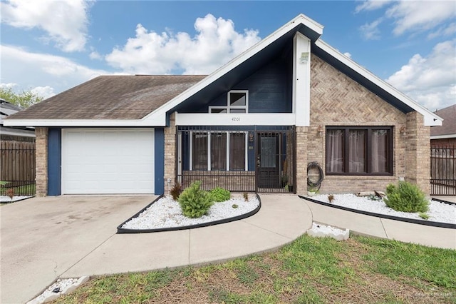 mid-century inspired home with an attached garage, fence, a shingled roof, brick siding, and driveway