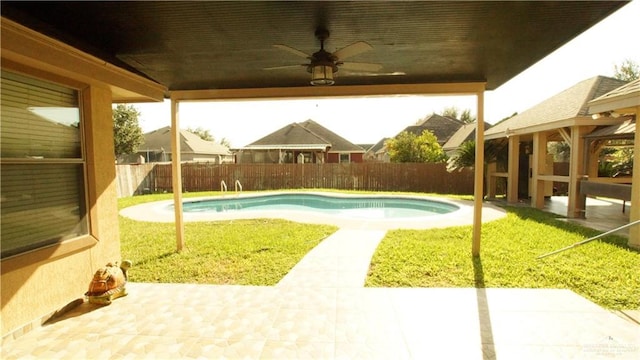 view of swimming pool with a yard, ceiling fan, and a patio area