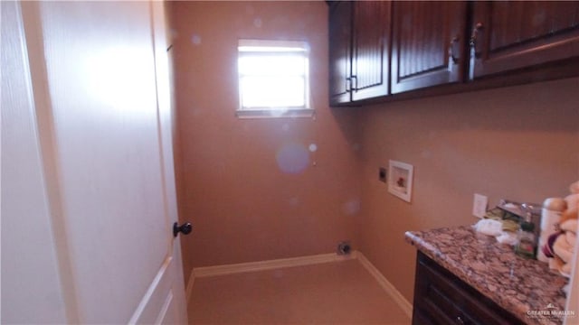 clothes washing area featuring hookup for a washing machine and cabinets