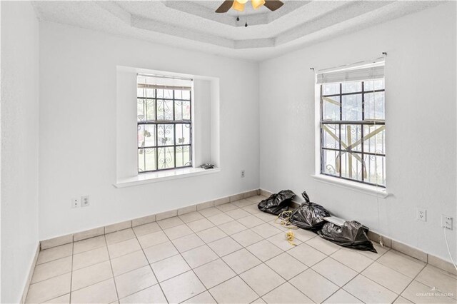 unfurnished room featuring ceiling fan, light tile patterned floors, and a textured ceiling