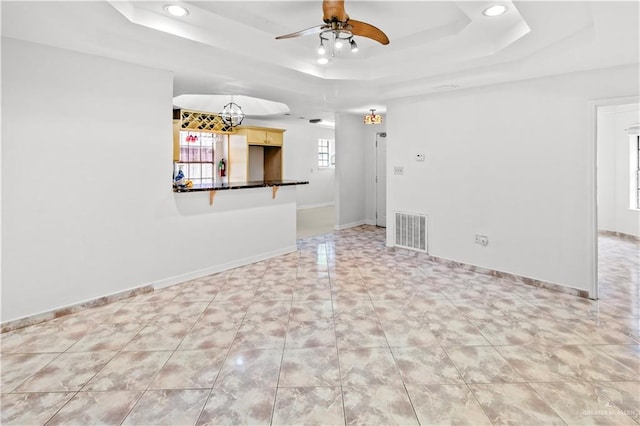 spare room with a tray ceiling and ceiling fan