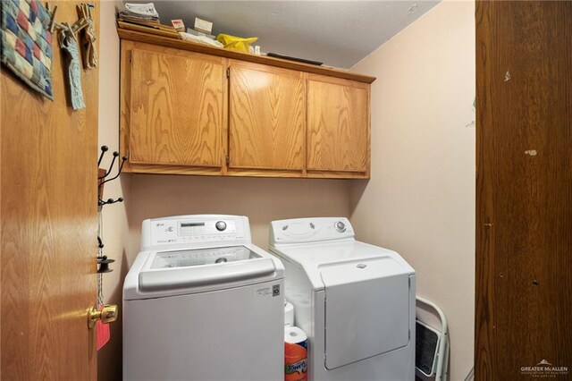 washroom with cabinets and washing machine and dryer