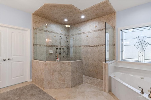 bathroom with tile patterned floors and shower with separate bathtub