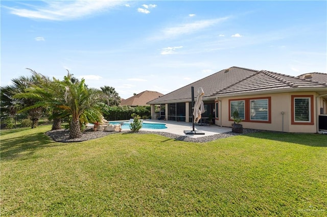 rear view of property featuring a lawn and a patio