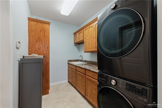 washroom with stacked washer and dryer, cabinets, and sink